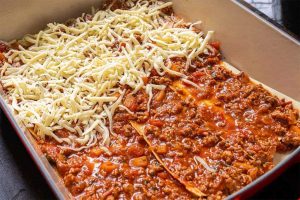A vibrant lasagna layered with noodles, meat sauce, and bubbly cheese in a baking dish